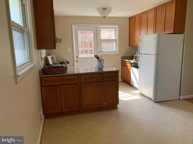a kitchen with a refrigerator sink stove and cabinets