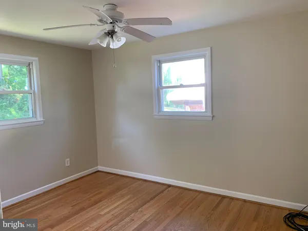 an empty room with a window and a fan