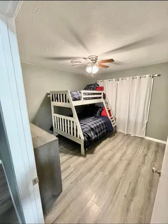 a black and white room with wooden floor stairs and a rug