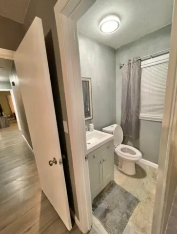 a bathroom with a granite countertop sink toilet and shower