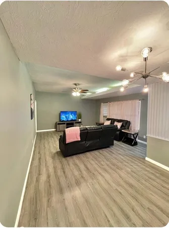 a living room with furniture and a wooden floor