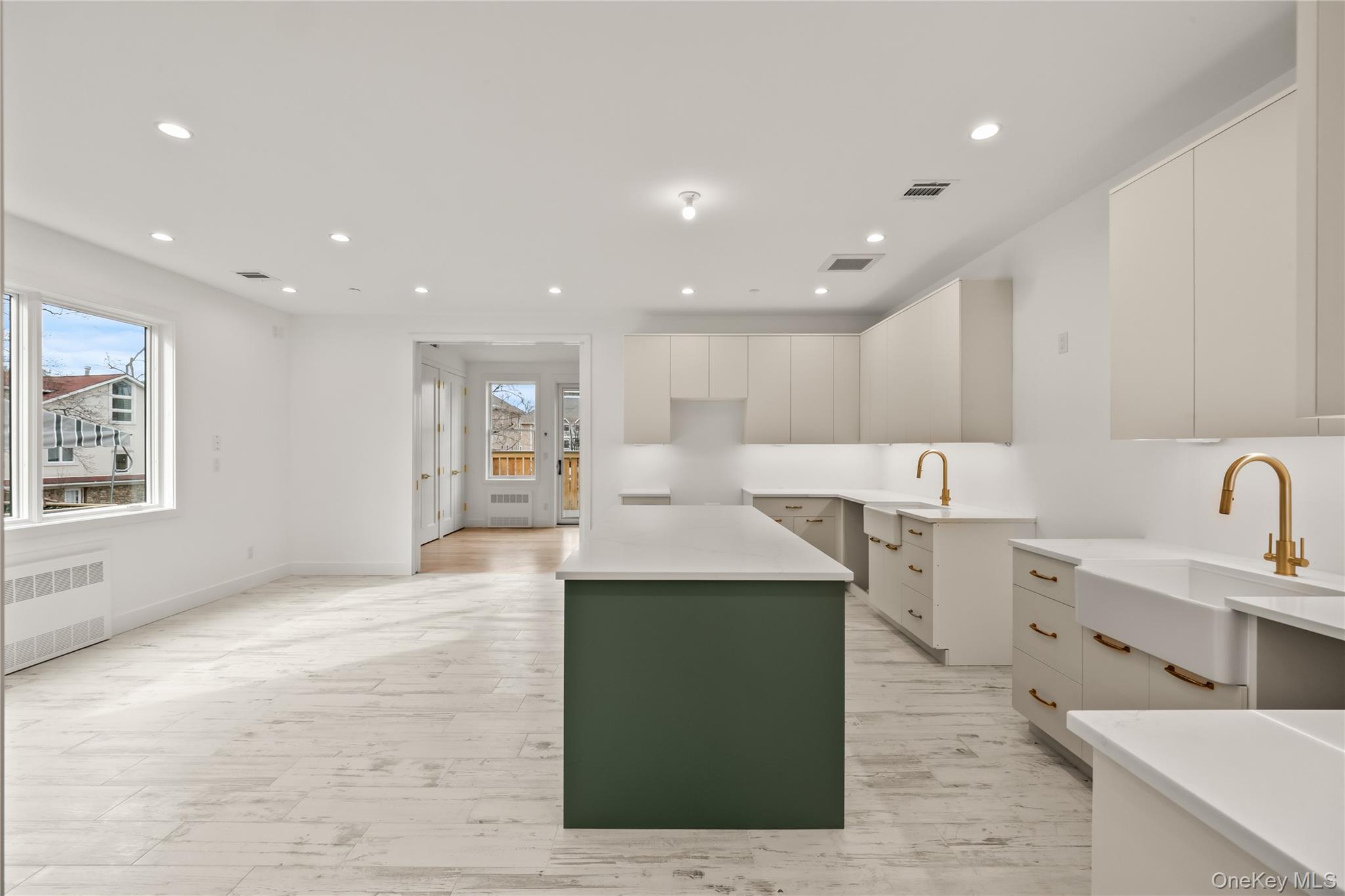 23 Singer Avenue, Unit 211 Spring Valley, NY 10977 - Photo 13 of 45 a large kitchen with stainless steel appliances kitchen island a sink dishwasher a stove and a refrigerator with wooden floor