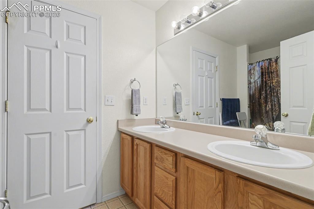 2579 Malpaso Point Colorado Springs, CO 80922 - Photo 7 of 15 a bathroom with a double vanity sink and a mirror