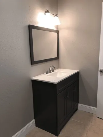 a bathroom with a sink vanity and mirror