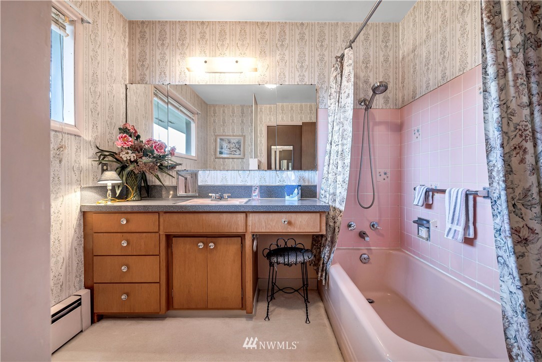 426 Bayside Road Bellingham, WA 98225 - Photo 24 of 40 a bathroom with a granite countertop sink a large mirror a bathtub and next to a window