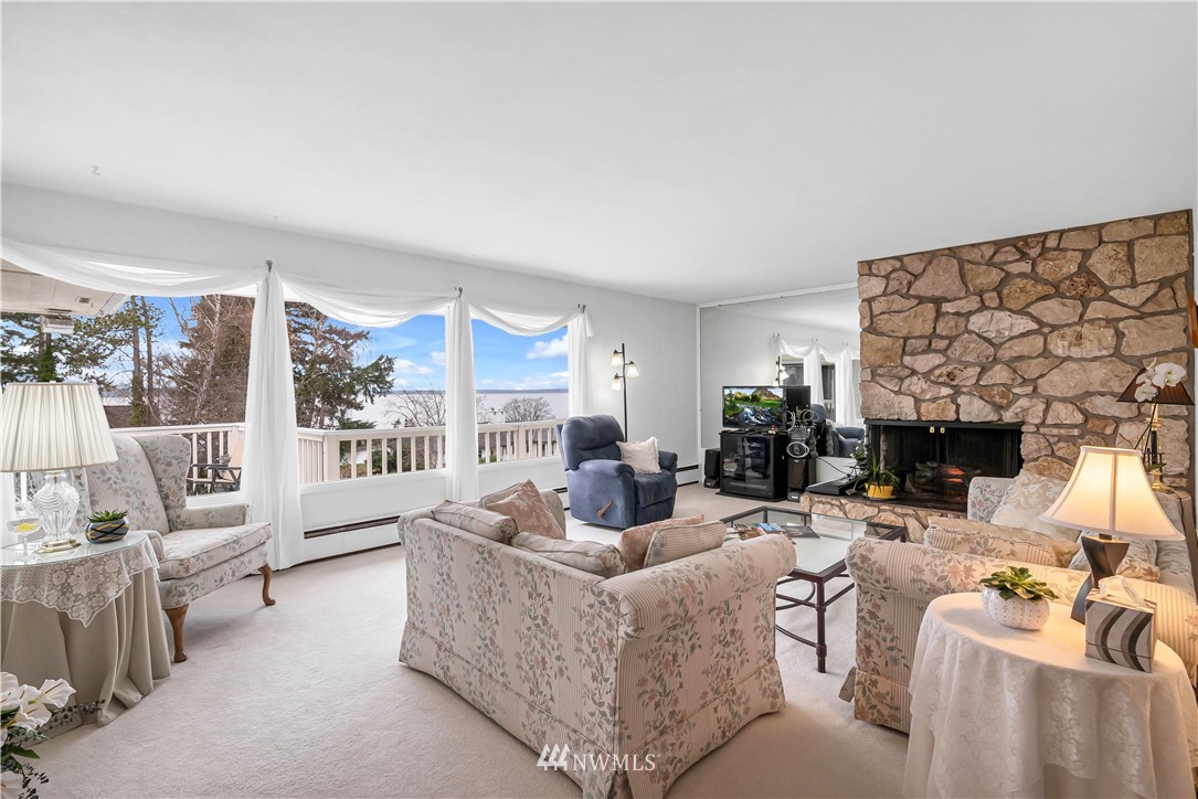 426 Bayside Road Bellingham, WA 98225 - Photo 6 of 40 a living room with furniture a fireplace and a floor to ceiling window