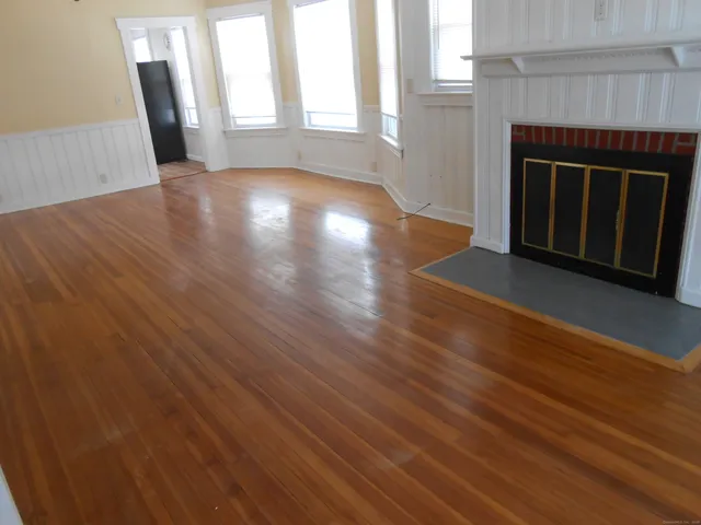 an empty room with wooden floor and fireplace