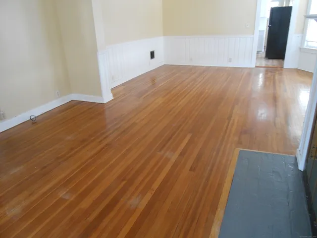 a view of an empty room with wooden floor