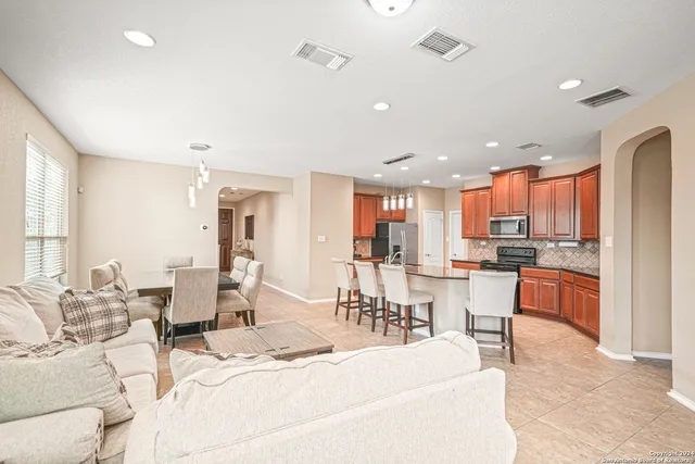 a open kitchen with stainless steel appliances granite countertop a stove and a refrigerator