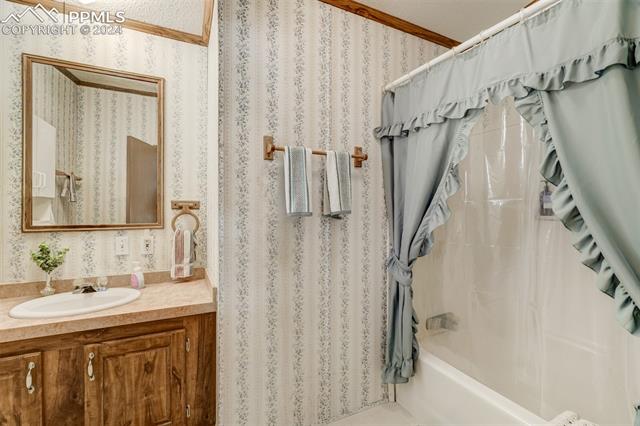 5845 Peerless Farms Road Peyton, CO 80831 - Photo 27 of 50 Bathroom featuring shower / bath combo, crown molding, and vanity