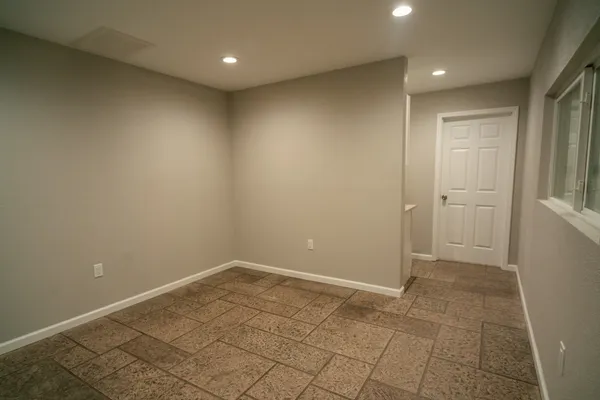 en empty room with white walls and tiles