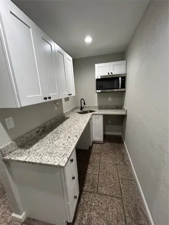 a kitchen with a sink a stove and cabinets