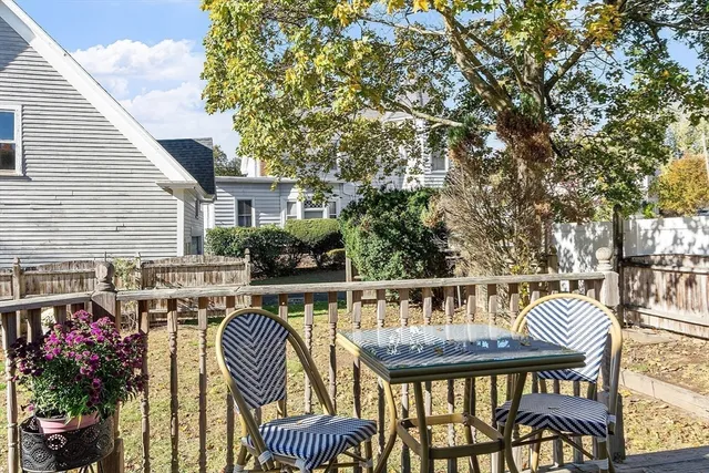 a balcony with wooden floor table and chairs