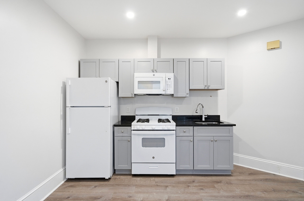 14-16 Ripley Street Malden, MA 02148 - Photo 5 of 37 a kitchen with a stove a refrigerator and a sink