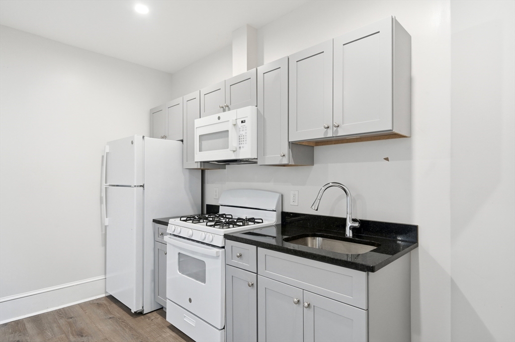 14-16 Ripley Street Malden, MA 02148 - Photo 6 of 37 a kitchen with stainless steel appliances granite countertop a sink stove refrigerator and cabinets