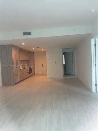 a view of an empty room with a kitchen