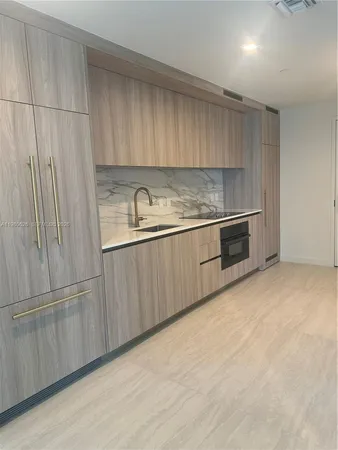 an empty room with kitchen view