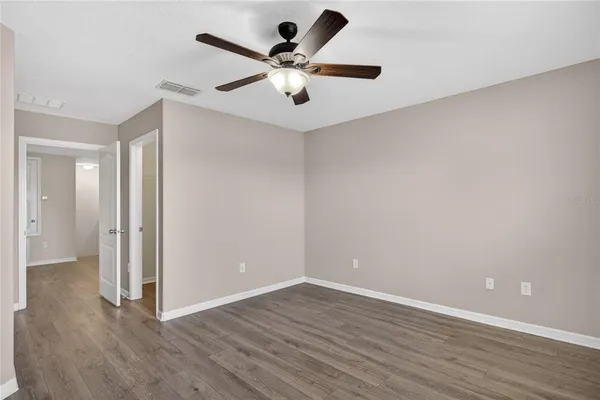 a view of an empty room with wooden floor