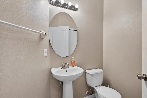 a bathroom with a sink mirror and toilet