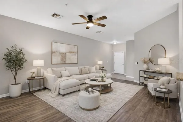 a living room with furniture a window and a potted plant