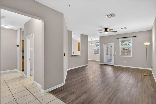 a view of an empty room with window and wooden floor