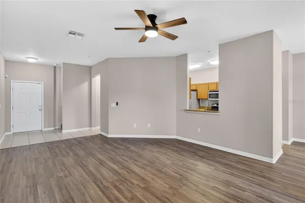 a view of an empty room with window and wooden floor