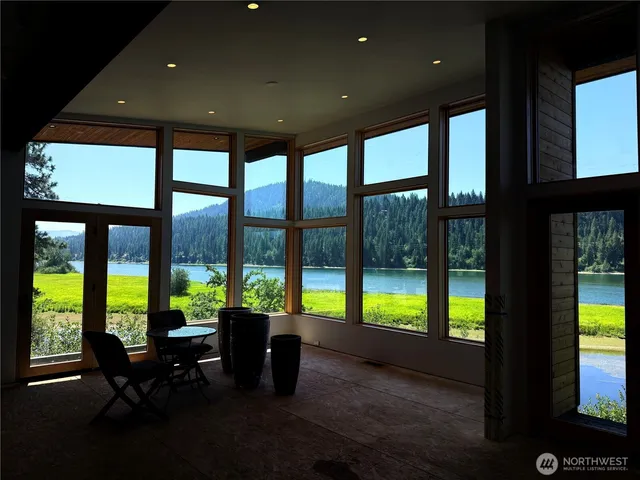 a living room with furniture and floor to ceiling windows