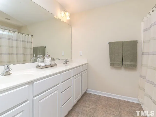 a bathroom with a double vanity sink a mirror and shower