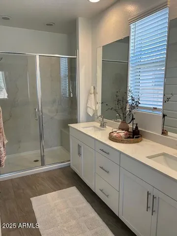 a bathroom with double vanity and a shower