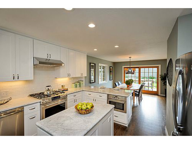 113 Channing Road Burlingame, CA 94010 - Photo 9 of 25 a kitchen with stainless steel appliances granite countertop a stove top oven a dining table and chairs with wooden floor