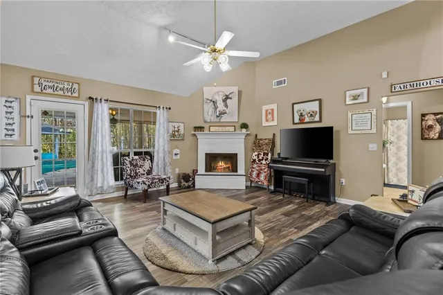 a living room with furniture a flat screen tv and a fireplace