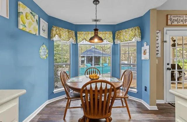 a dining room with furniture front door and wooden floor