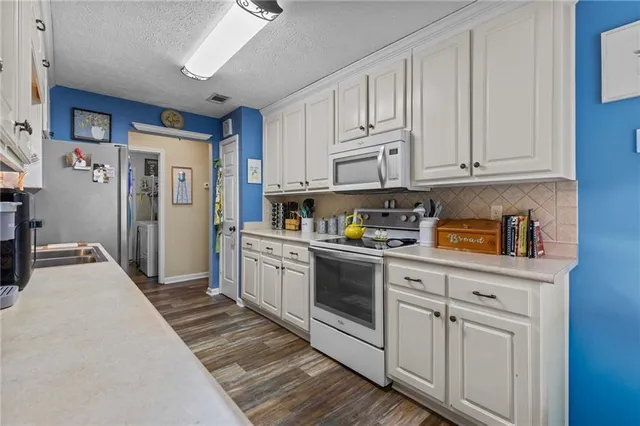 a kitchen with white cabinets and white appliances
