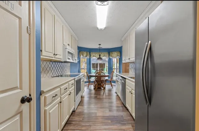 a kitchen with kitchen island wooden floor center island and stainless steel appliances