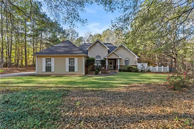 a front view of a house with a yard and trees