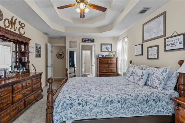 a spacious bedroom with a bed and dresser