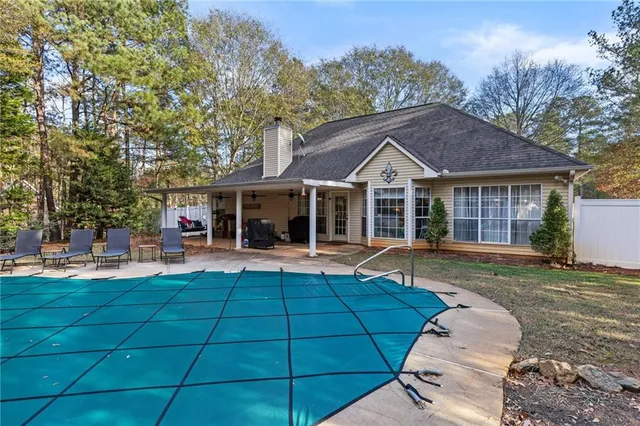 a front view of a house with swimming pool and furniture