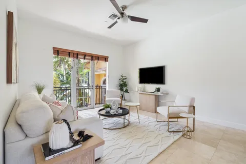 a living room with furniture a flat screen tv and a large window