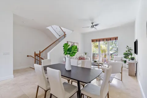a dining room with furniture potted plants and wooden floor