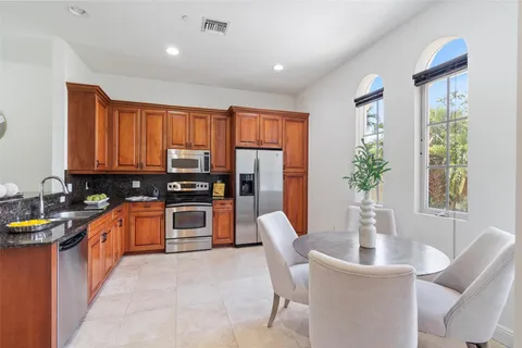 a kitchen with stainless steel appliances granite countertop a refrigerator and a stove top oven