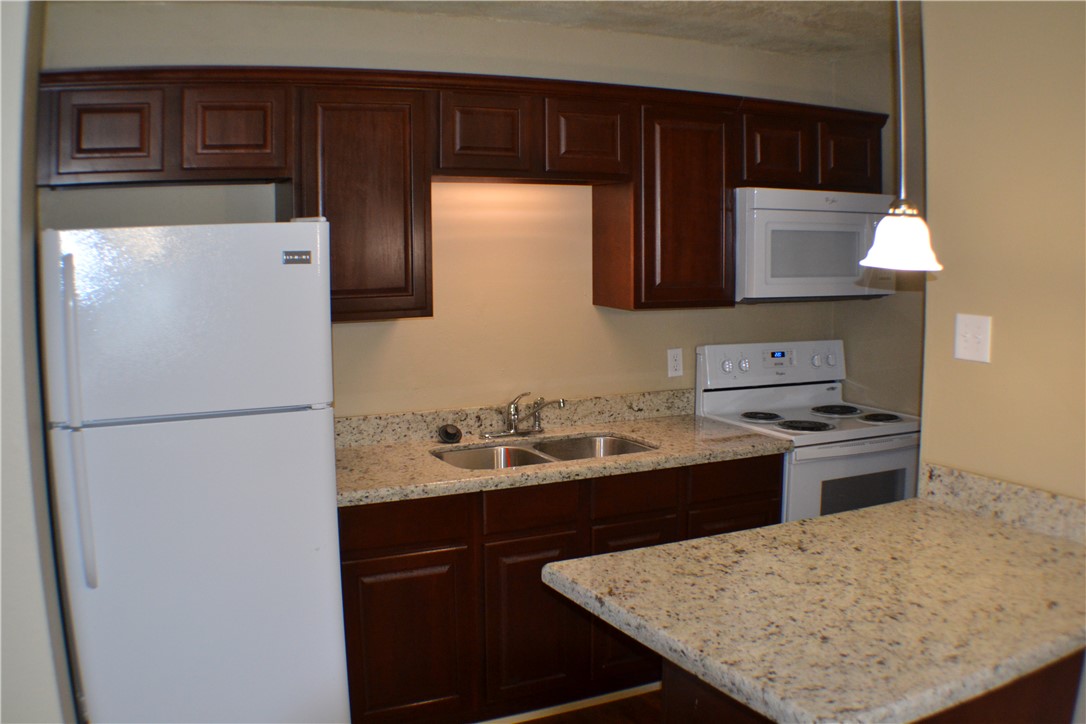 4212 Old College Road, Unit 7 Bryan, TX 77801 - Photo 3 of 19 a kitchen with a sink refrigerator and stove
