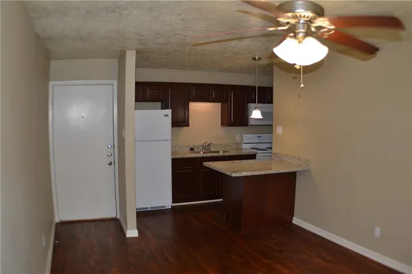 a kitchen with a sink cabinets and wooden floor