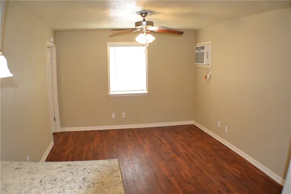 an empty room with a window and a ceiling fan