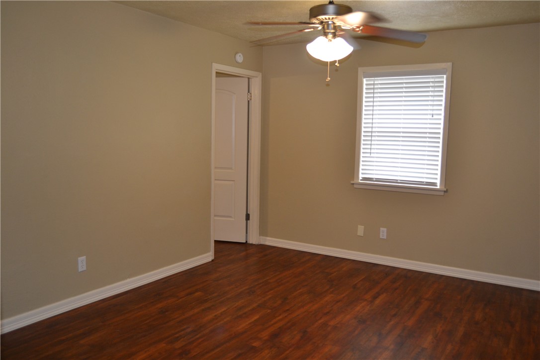 4212 Old College Road, Unit 7 Bryan, TX 77801 - Photo 7 of 19 a view of an empty room with wooden floor and a window