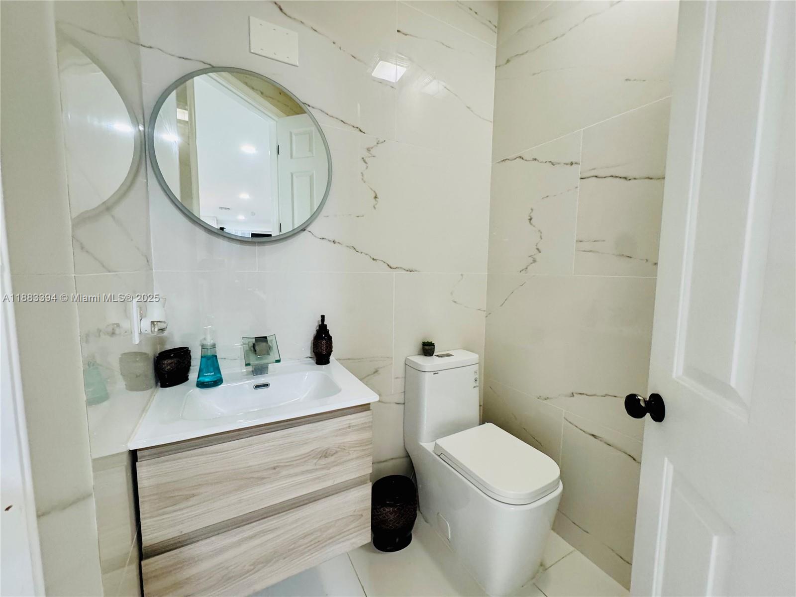 7408 Southwest 189th Street Cutler Bay, FL 33157 - Photo 14 of 25 a bathroom with a toilet sink and mirror