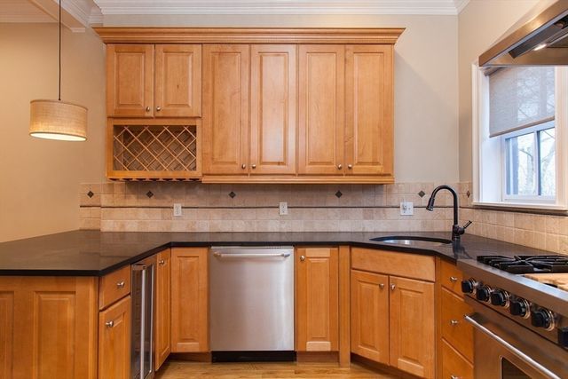 a kitchen with granite countertop wooden cabinets and a stove top oven