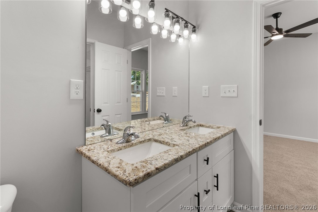 802 Holmes Street Clinton, NC 28328 - Photo 15 of 31 a bathroom with a granite countertop sink a mirror and a vanity