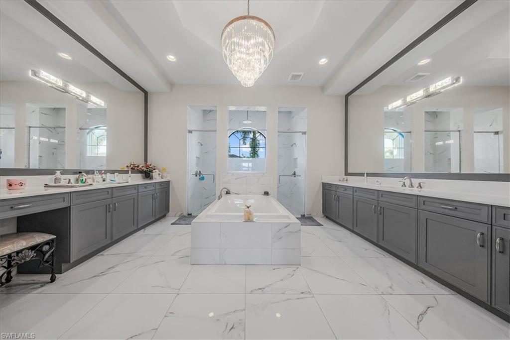 4616 Azalea Drive Naples, FL 34119 - Photo 15 of 44 Bathroom featuring a marble finish shower, two vanities, a bath, recessed lighting, and a chandelier