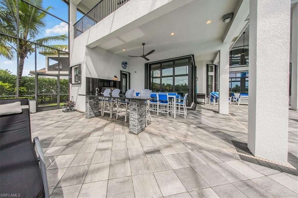 4616 Azalea Drive Naples, FL 34119 - Photo 30 of 44 Patio / terrace featuring a sunroom, glass enclosure, outdoor dining space, ceiling fan, and a patio
