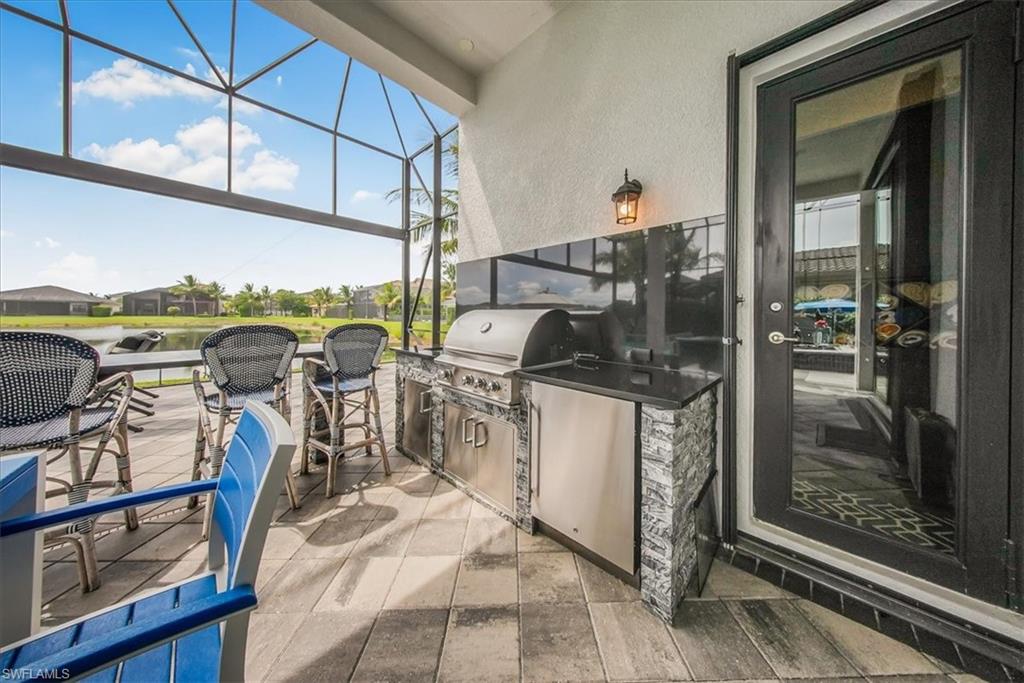 4616 Azalea Drive Naples, FL 34119 - Photo 31 of 44 View of patio featuring a sunroom, glass enclosure, and an outdoor kitchen